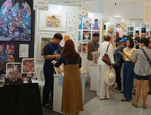 Crowded comic art festival hall with illustrated prints and artist booths