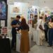 Crowded comic art festival hall with illustrated prints and artist booths